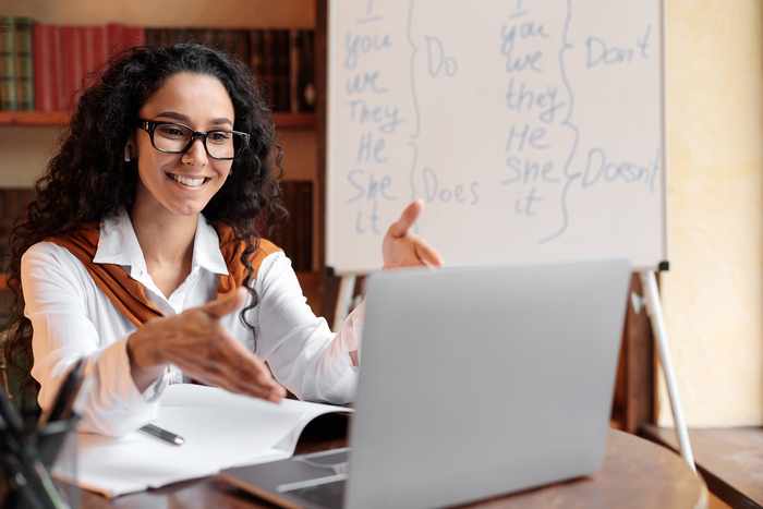 Profesora egresada del diplomado de habilidades digitales para la docencia dando clases en línea y viendo hacia su computadora